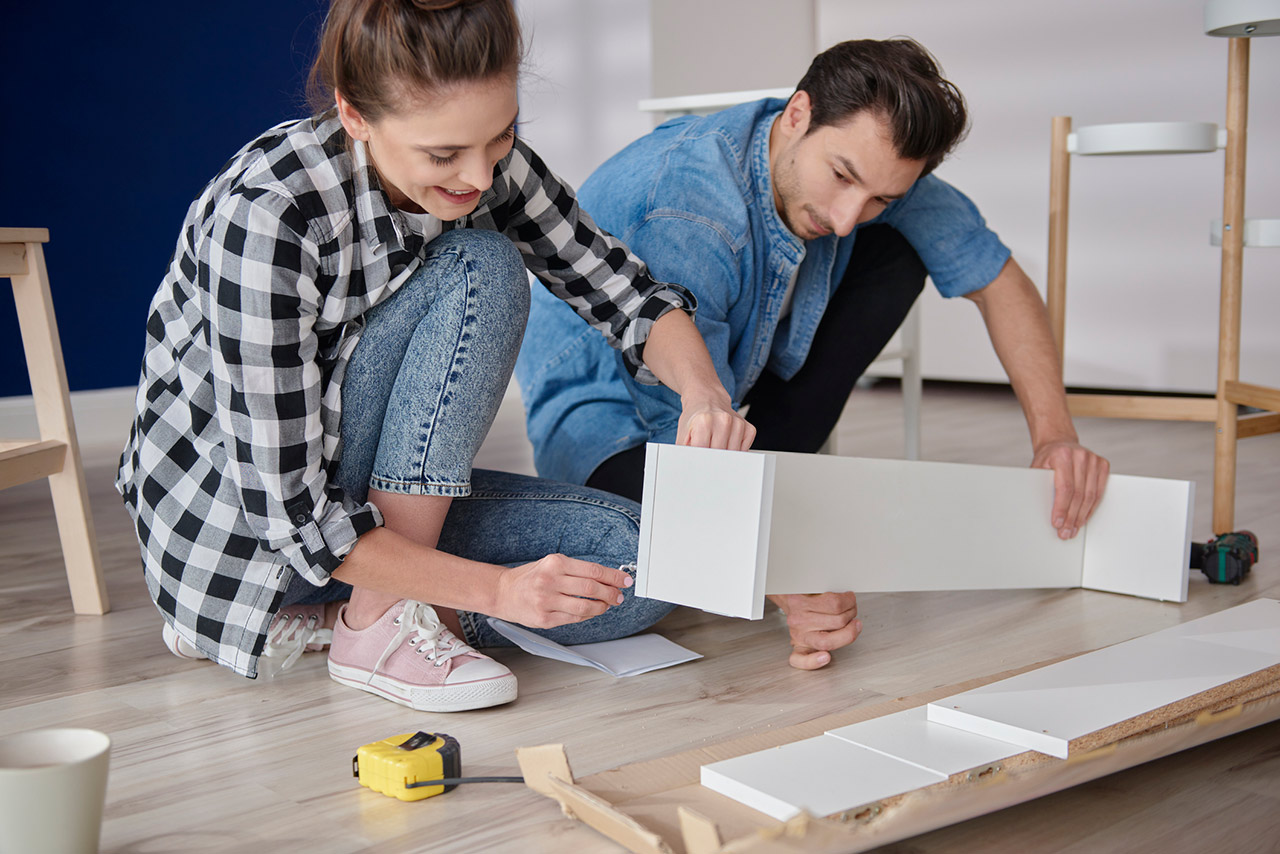 couple installing bookshelf for new house stock photo