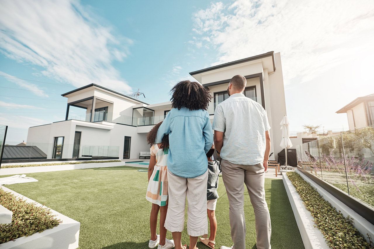 new house and family in their backyard together looking at their property